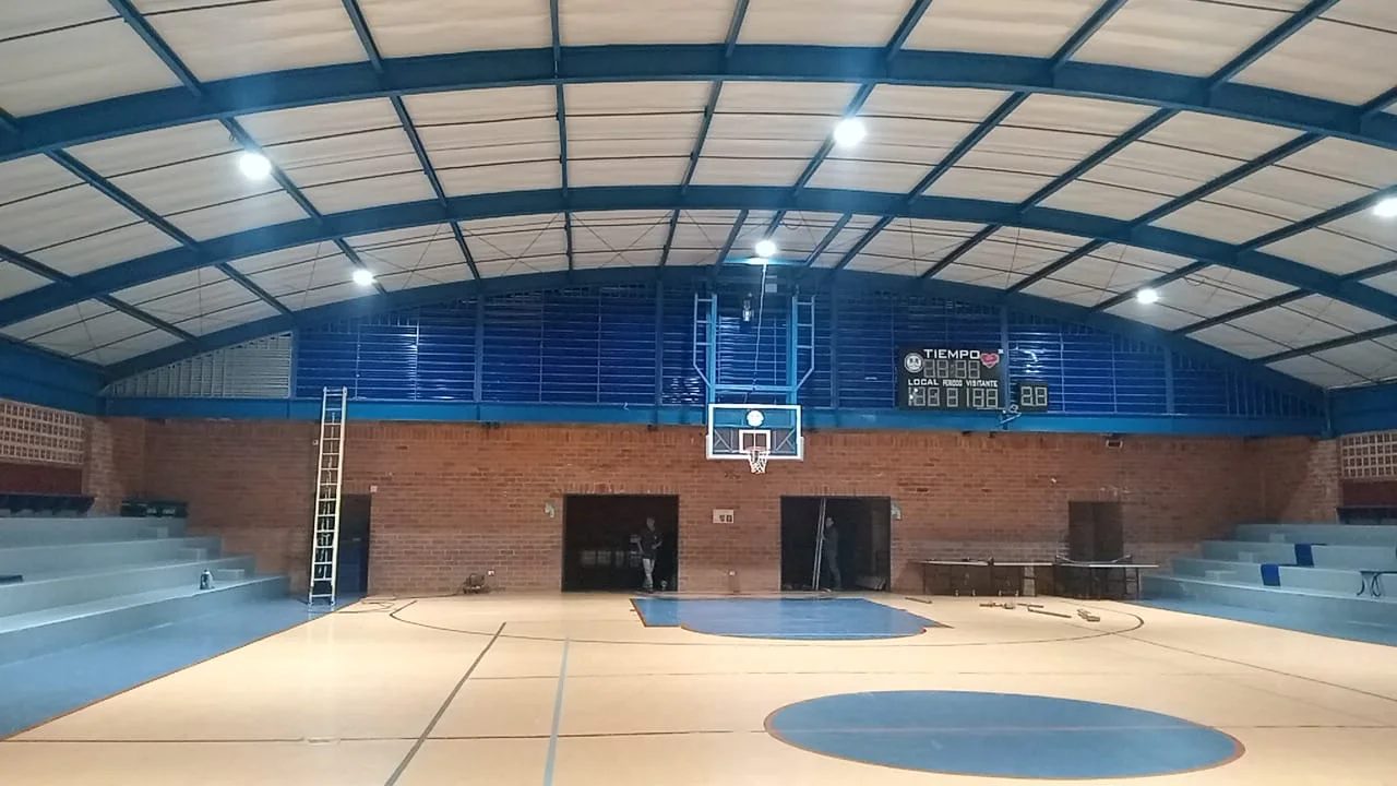Vista interior de una cancha con estructura y cubierta metálica